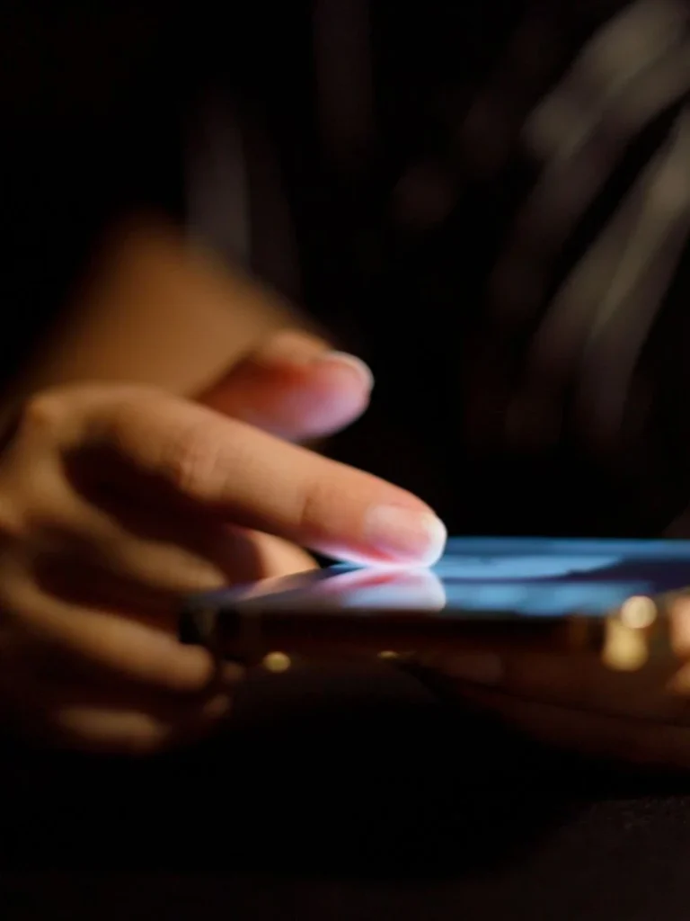 Close-up of hands using a smartphone.